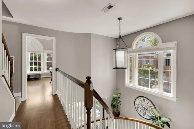 a view of a hallway with wooden floor and a chandelier