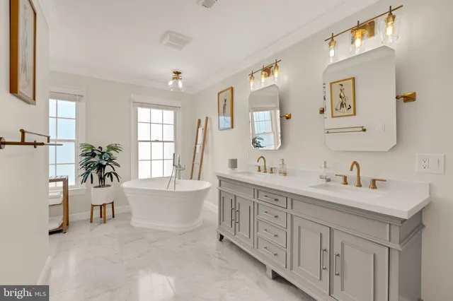 a spacious bathroom with a double vanity sink a mirror a window and a bathtub