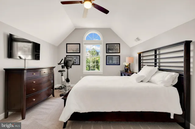 a bedroom with a bed and a flat tv screen on dresser