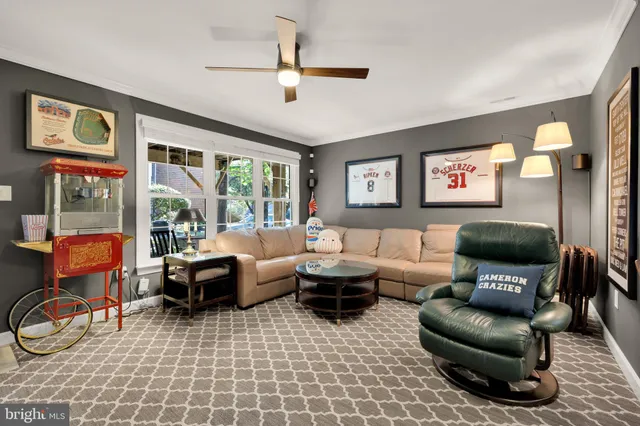 a living room with furniture a flat screen tv and a floor to ceiling window