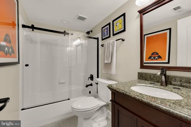 a bathroom with a granite countertop sink toilet and shower
