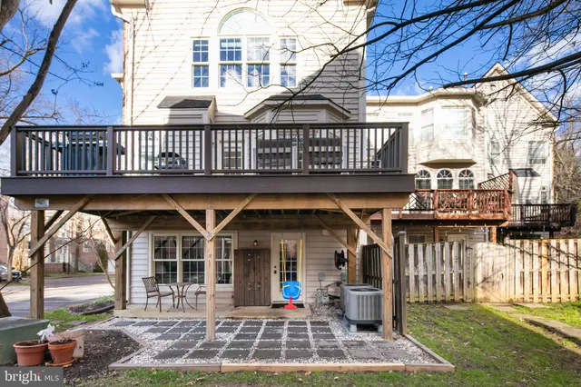 a view of a brick house with floor to ceiling windows and yard