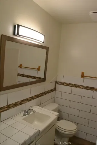 a bathroom with a sink a toilet and mirror