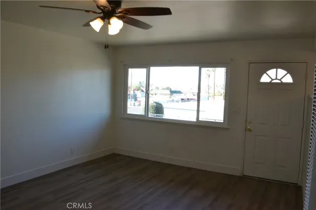 en empty room with wooden floor and windows