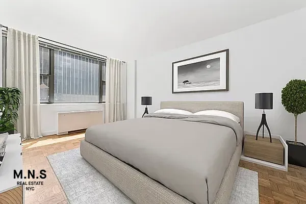 a bedroom with a bed and a lamp on table chair