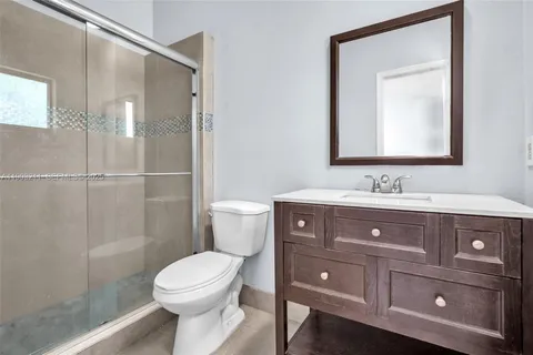 a bathroom with a toilet a sink and mirror