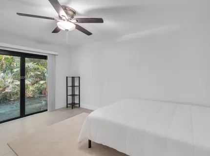 a spacious bedroom with a bed and a large window