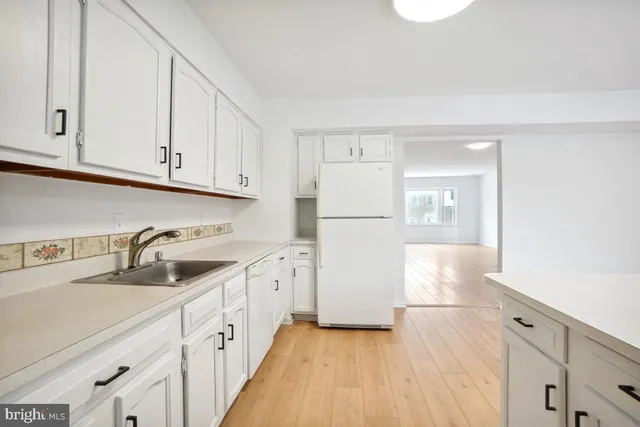 a kitchen with appliances a sink and cabinets