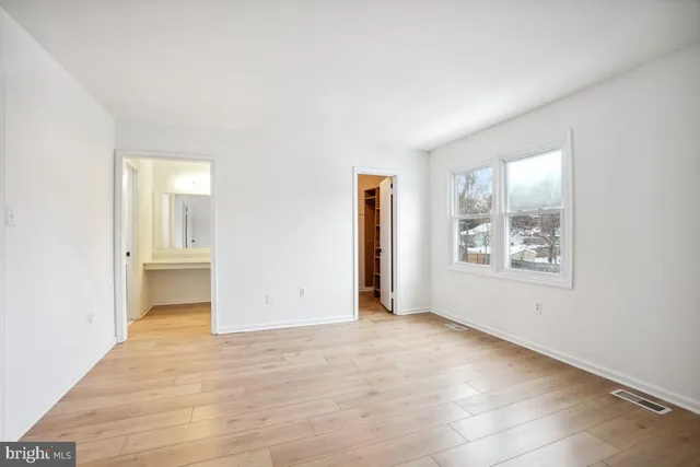 an empty room with windows and closet