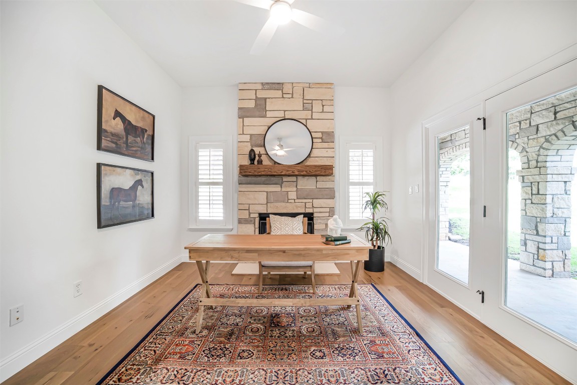 10903 Centennial Trail Austin, TX 78726 - Photo 16 of 31 Home office with a fireplace, light wood-style flooring, and ceiling fan