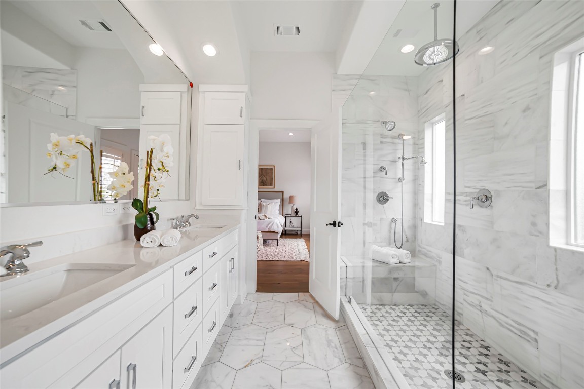10903 Centennial Trail Austin, TX 78726 - Photo 19 of 31 Primary ensuite bathroom featuring marble look tile flooring, a shower stall, double vanity, and recessed lighting