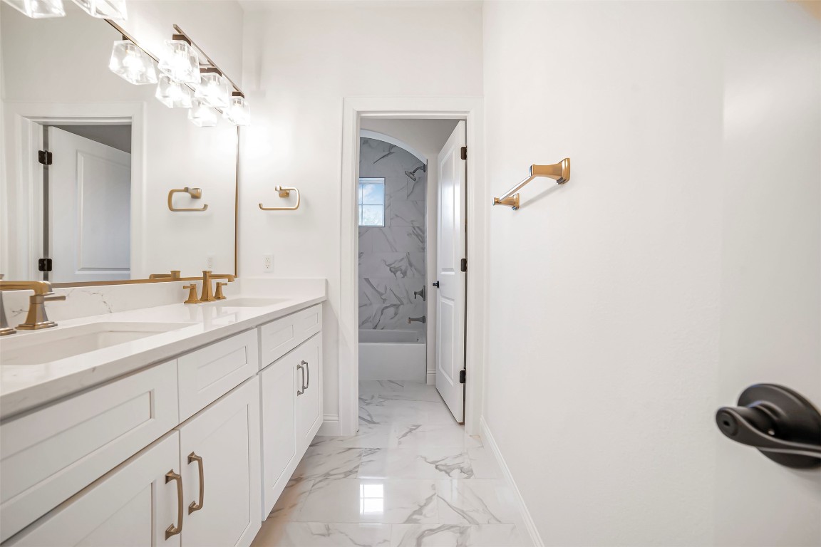 10903 Centennial Trail Austin, TX 78726 - Photo 25 of 31 Bathroom with marble finish floors, double vanity, and tub / shower combination