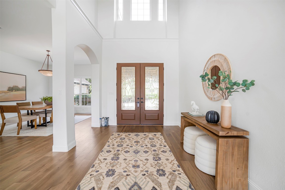 10903 Centennial Trail Austin, TX 78726 - Photo 4 of 31 Foyer with arched walkways, french doors, wood finished floors, and a towering ceiling