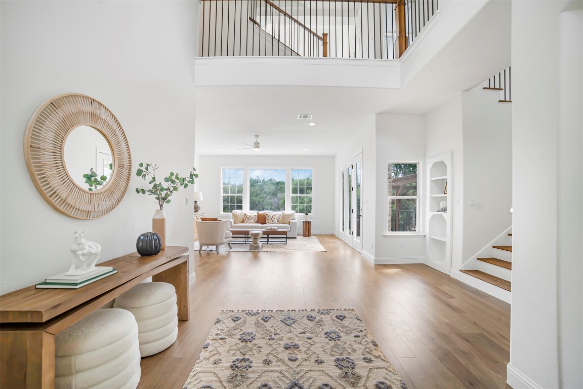 10903 Centennial Trail Austin, TX 78726 - Photo 5 of 31 Entryway with hardwood / wood-style flooring, stairs, and high ceiling
