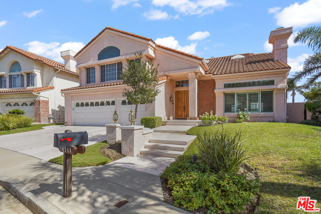 19584 Shadow Ridge Way Porter Ranch, CA 91326 - Photo 1 of 4 a front view of a house with garden