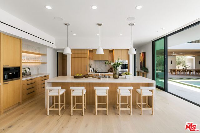 a living room with furniture floor to ceiling window and a flat screen tv