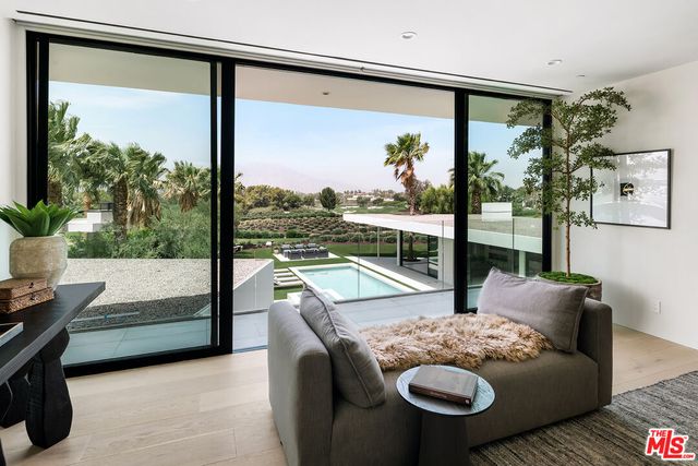 a dining room with furniture a large window and a chandelier