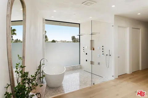 a spacious bedroom with a bed and glass door