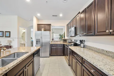 a kitchen with granite countertop stainless steel appliances cabinets a sink and a counter top space