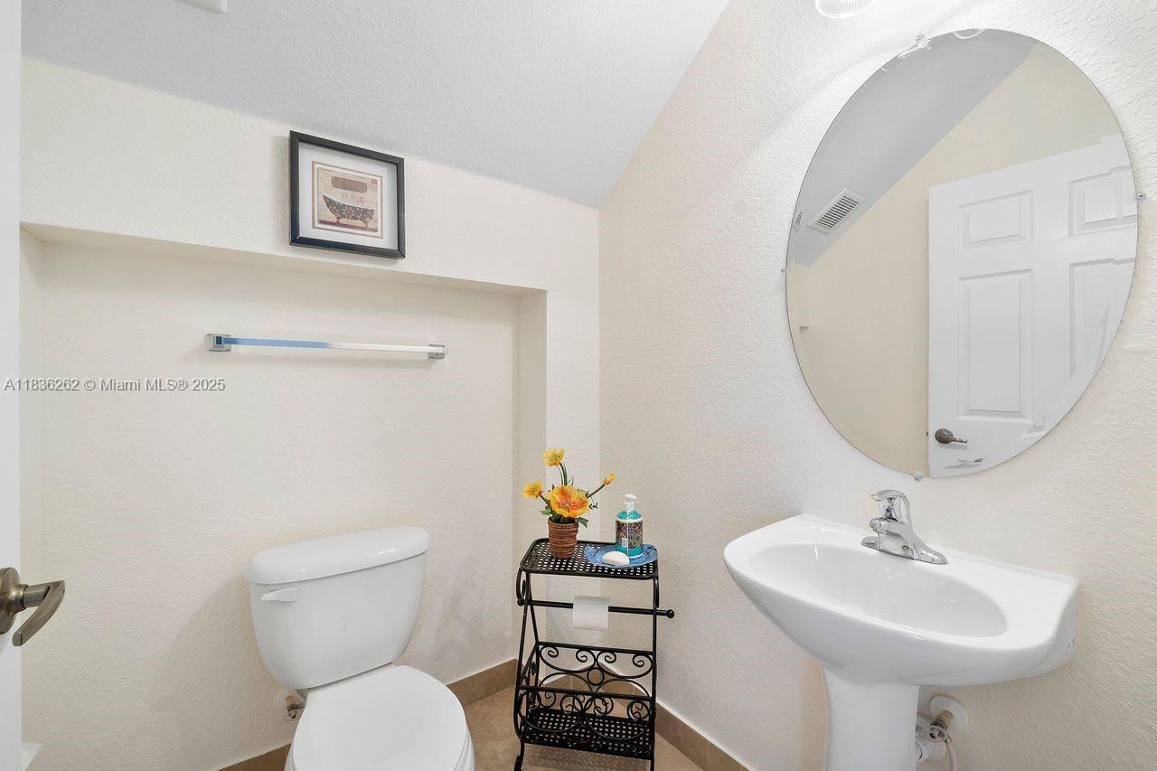 2851 Prospect Road, Unit 1306 Tamarac, FL 33309 - Photo 14 of 39 a bathroom with a toilet a sink and a mirror