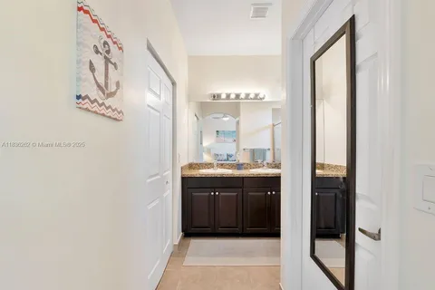 a bathroom with a granite countertop sink a mirror and a bathtub