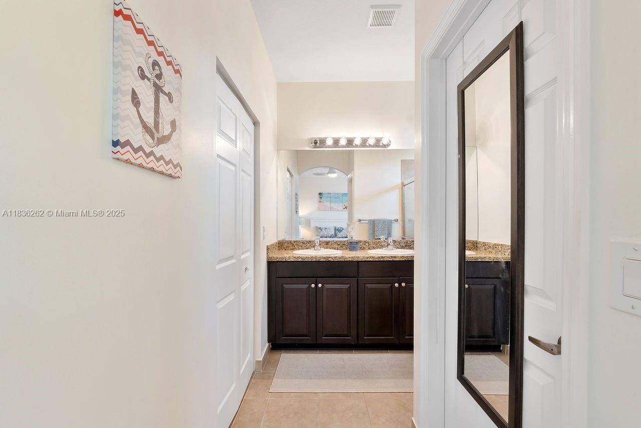 2851 Prospect Road, Unit 1306 Tamarac, FL 33309 - Photo 19 of 39 a bathroom with a granite countertop sink a mirror and a bathtub