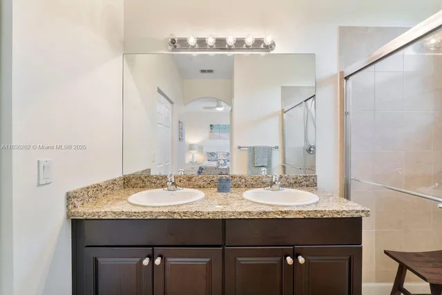 a bathroom with a granite countertop sink and a mirror