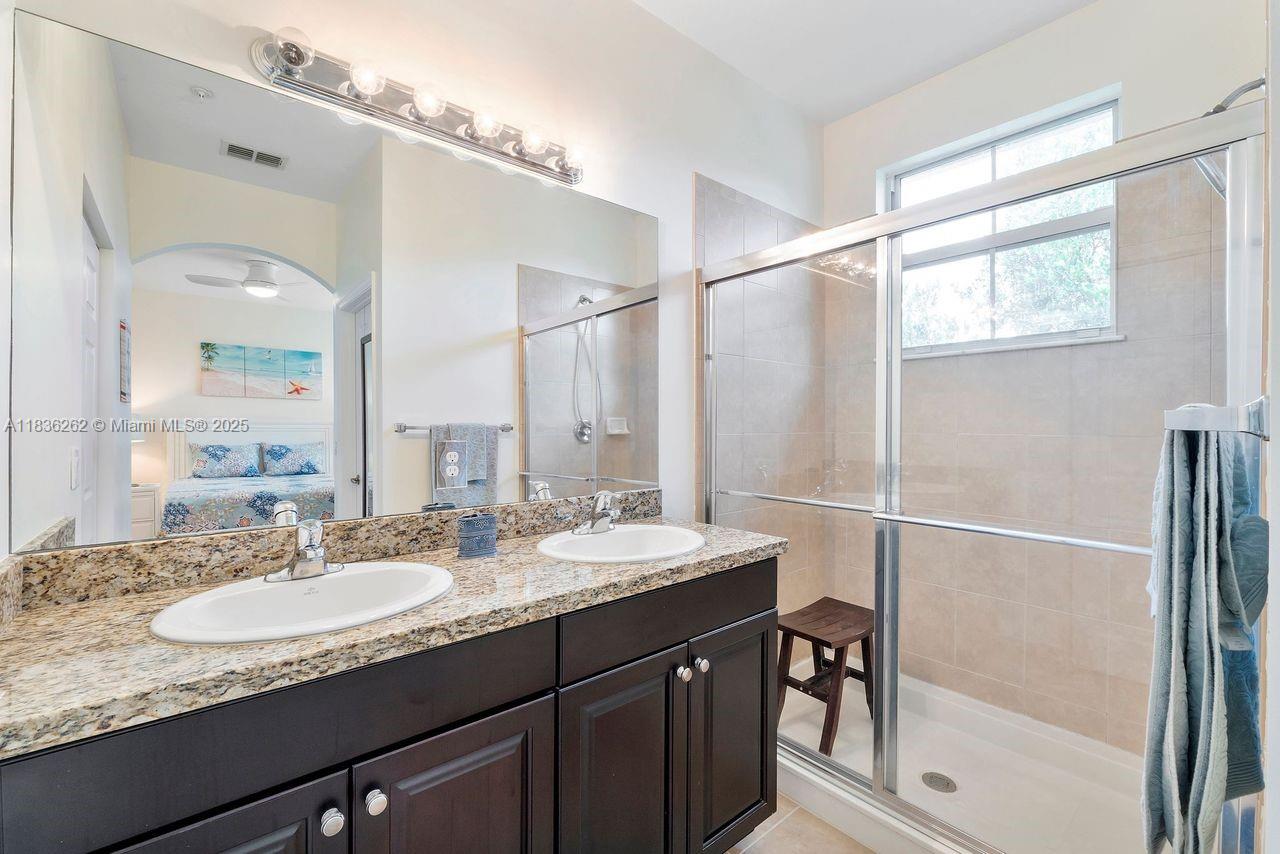 2851 Prospect Road, Unit 1306 Tamarac, FL 33309 - Photo 21 of 39 a bathroom with a granite countertop sink mirror and a shower