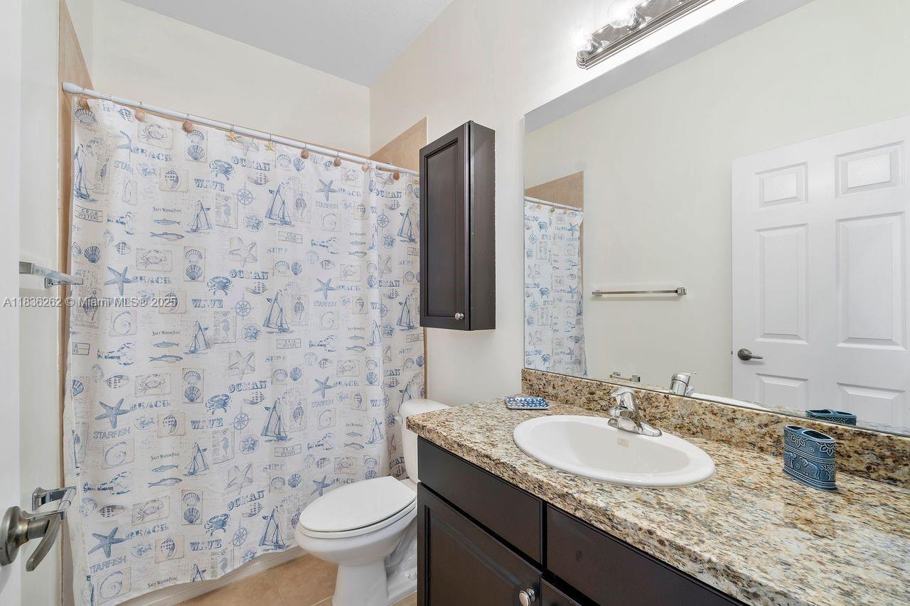 2851 Prospect Road, Unit 1306 Tamarac, FL 33309 - Photo 28 of 39 a bathroom with a granite countertop sink a toilet and a mirror