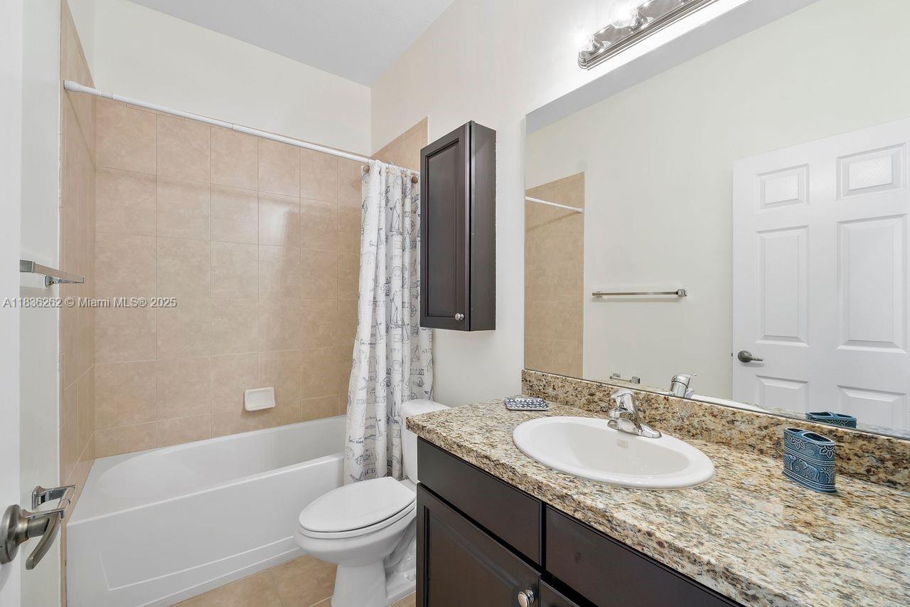 2851 Prospect Road, Unit 1306 Tamarac, FL 33309 - Photo 29 of 39 a bathroom with a granite countertop sink toilet and shower