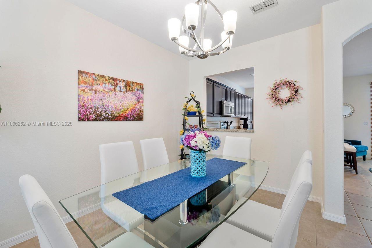 2851 Prospect Road, Unit 1306 Tamarac, FL 33309 - Photo 5 of 39 a view of a dining room with furniture and chandelier