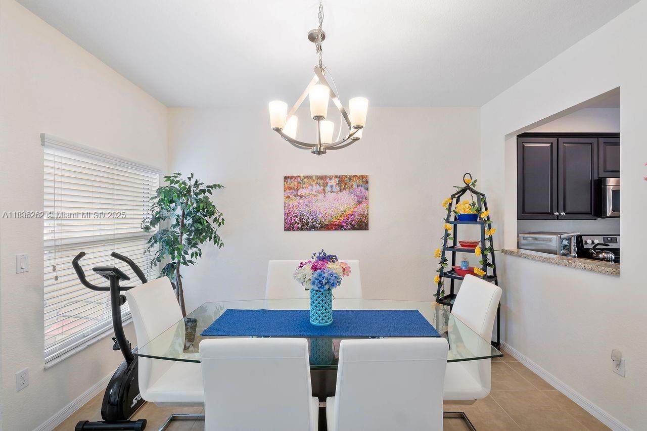 2851 Prospect Road, Unit 1306 Tamarac, FL 33309 - Photo 7 of 39 a view of a dining room with furniture and chandelier