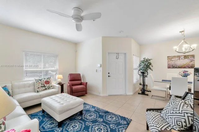 a living room with furniture a chandelier and a window