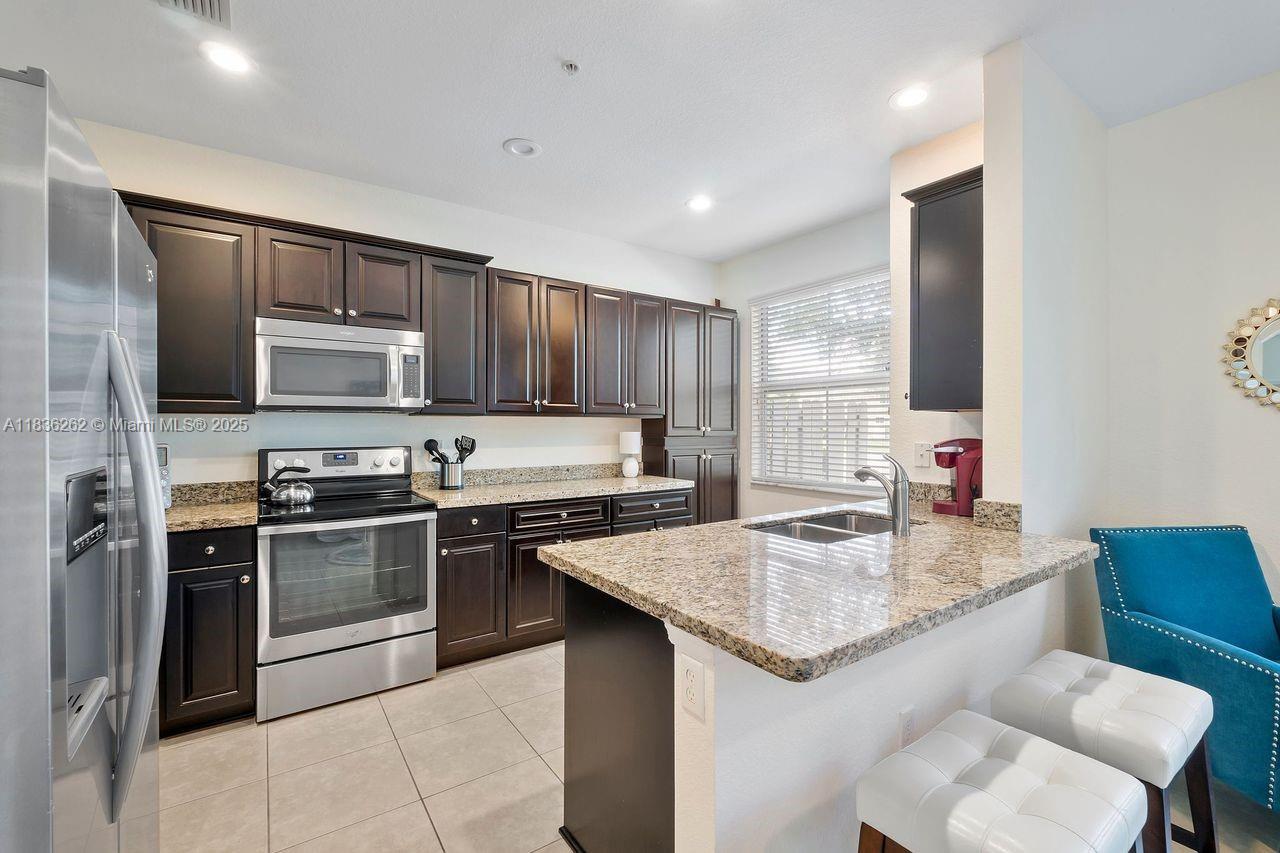 2851 Prospect Road, Unit 1306 Tamarac, FL 33309 - Photo 10 of 39 a kitchen with stainless steel appliances granite countertop a sink dishwasher stove top oven and refrigerator