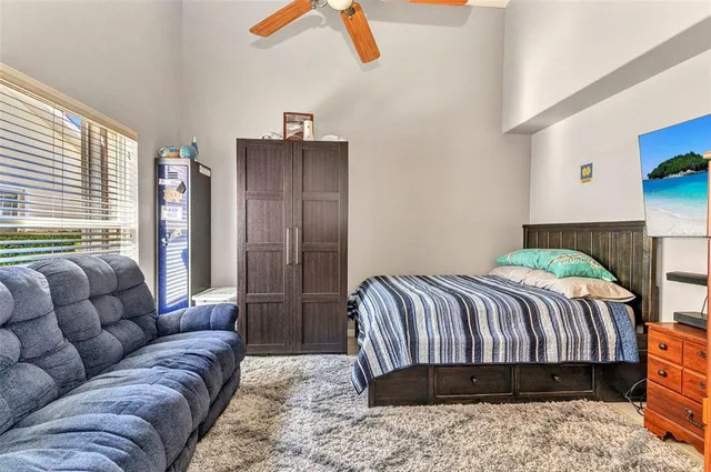 a bedroom with a bed couch and a large window