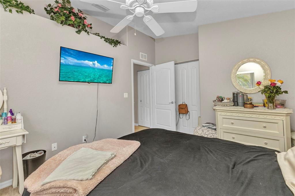 3715 Albacete Circle, Unit 93 Punta Gorda, FL 33950 - Photo 22 of 32 a bedroom with a bed and a chandelier