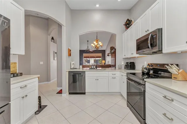 a kitchen with white cabinets and appliances