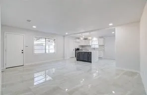a large white kitchen with a sink stainless steel appliances and cabinets