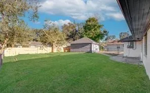 a view of backyard of house with green space