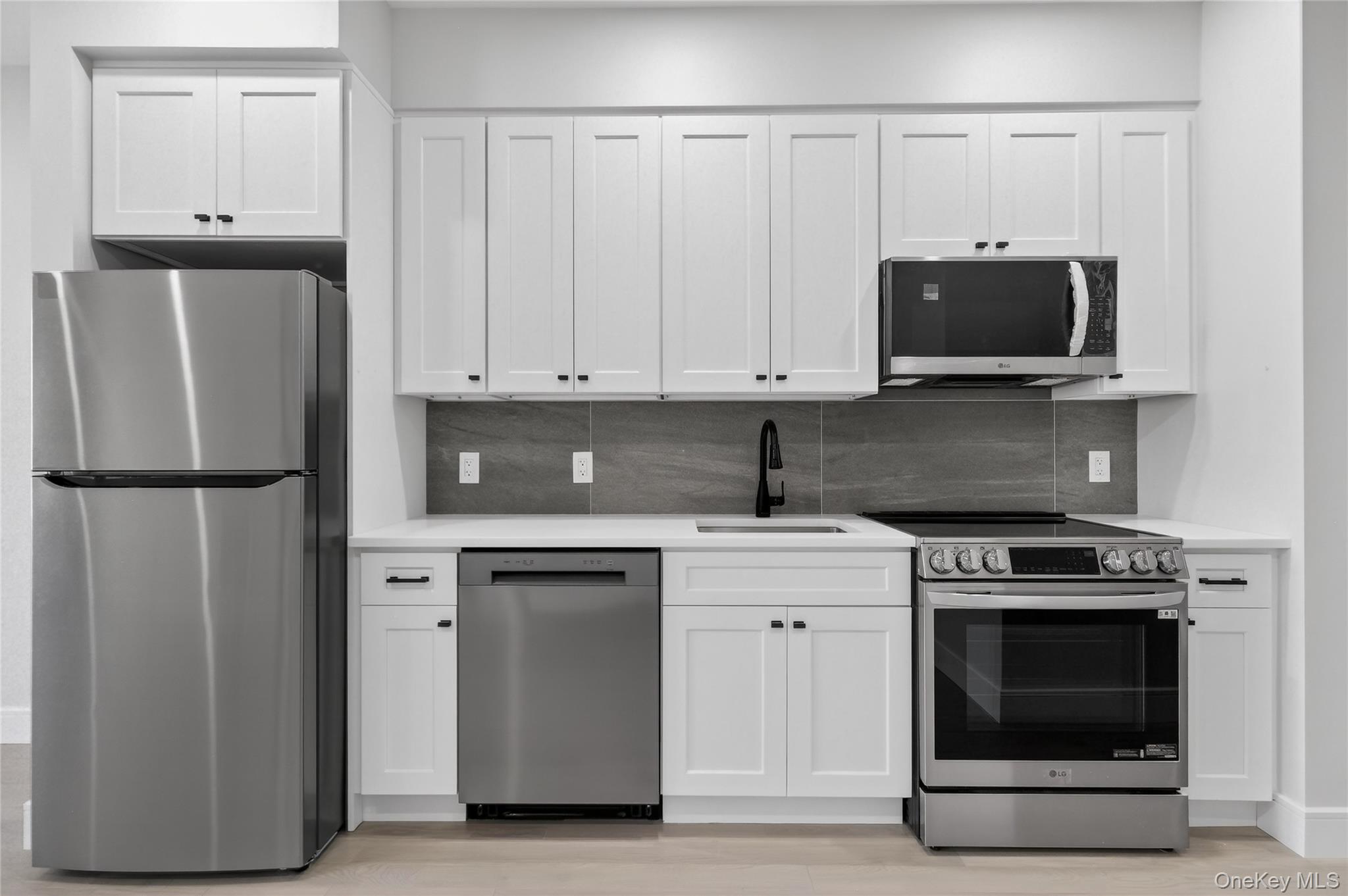 a kitchen with stainless steel appliances granite countertop a stove a microwave and a refrigerator