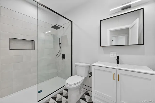 a bathroom with a toilet sink vanity and shower