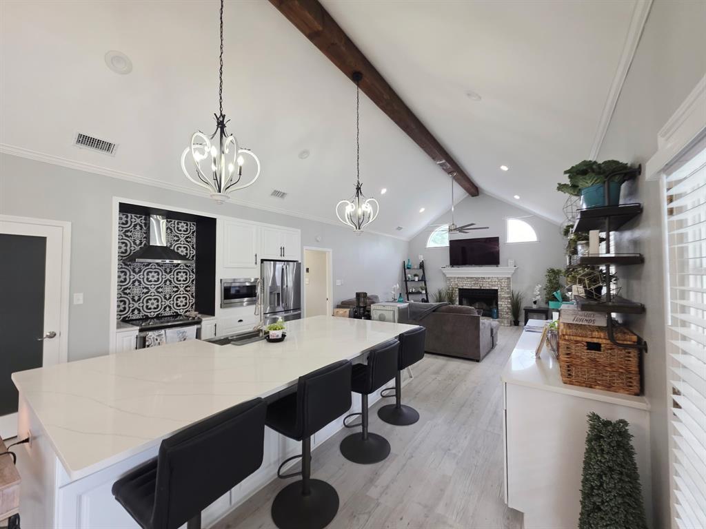 520 Red River Road Belton, TX 76513 - Photo 19 of 36 Spacious kitchen island with a white countertop and seating for four, complemented by modern pendant lighting