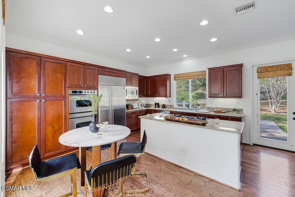 6103 Deerhill Road Oak Park, CA 91377 - Photo 11 of 40 a kitchen with stainless steel appliances granite countertop a stove a sink a microwave refrigerator and chairs