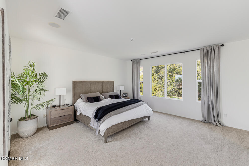 6103 Deerhill Road Oak Park, CA 91377 - Photo 18 of 40 a spacious bedroom with a bed and a large window