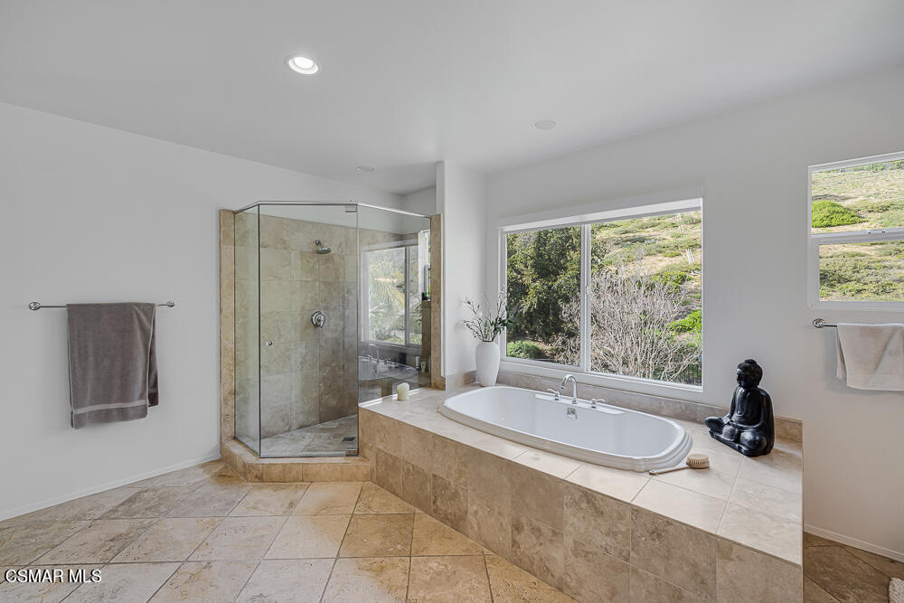 6103 Deerhill Road Oak Park, CA 91377 - Photo 21 of 40 a bathroom with a tub a sink a mirror and a shower