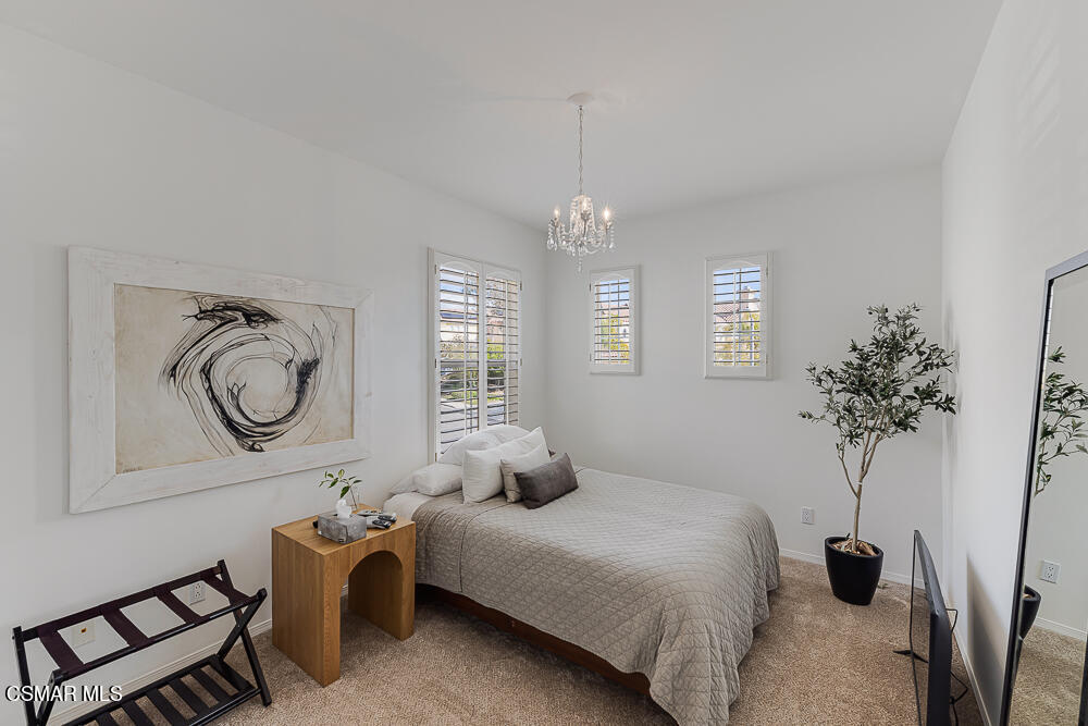 6103 Deerhill Road Oak Park, CA 91377 - Photo 25 of 40 a bedroom with bed and a chandelier