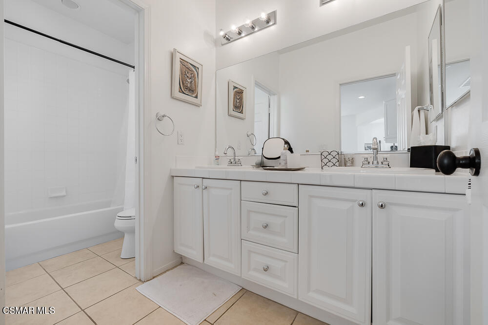 6103 Deerhill Road Oak Park, CA 91377 - Photo 26 of 40 a bathroom with a double vanity sink a toilet and a tub