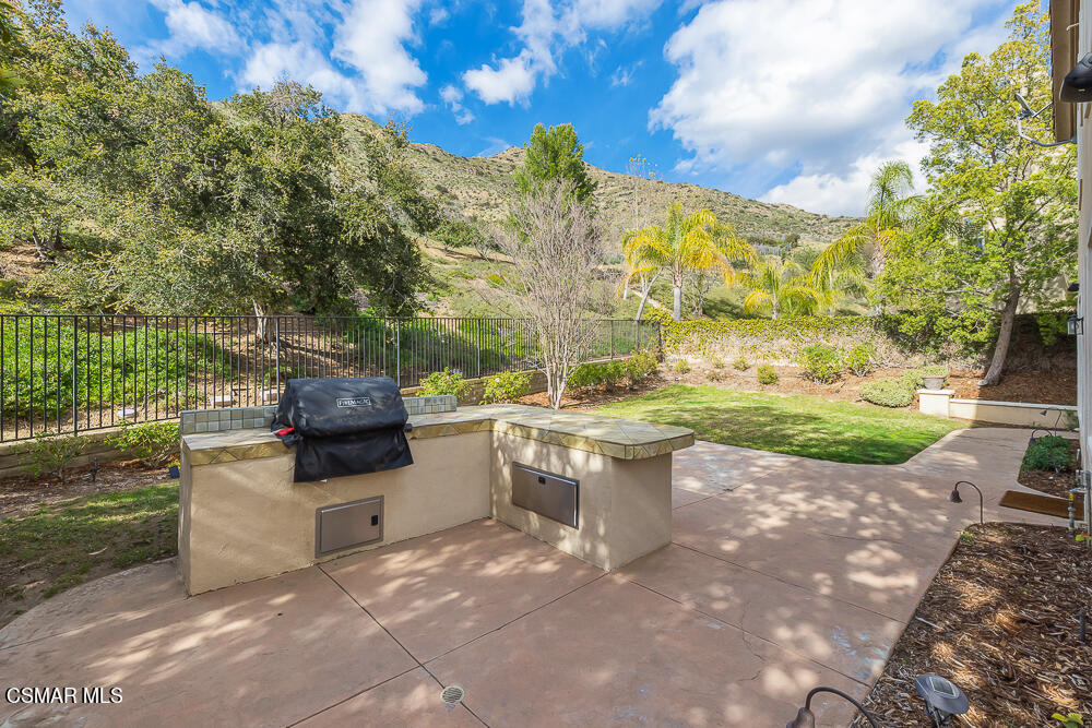 6103 Deerhill Road Oak Park, CA 91377 - Photo 39 of 40 a view of a patio with table and chairs and potted plants