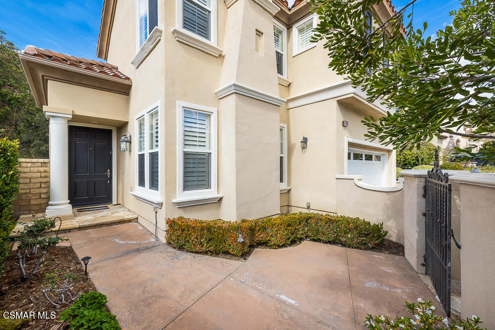 6103 Deerhill Road Oak Park, CA 91377 - Photo 4 of 40 a front view of a house with a yard and garage