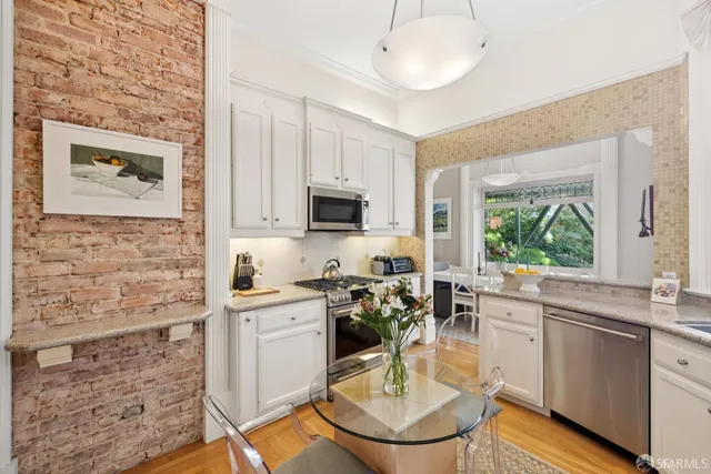 a kitchen with a sink cabinets a window and stainless steel appliances